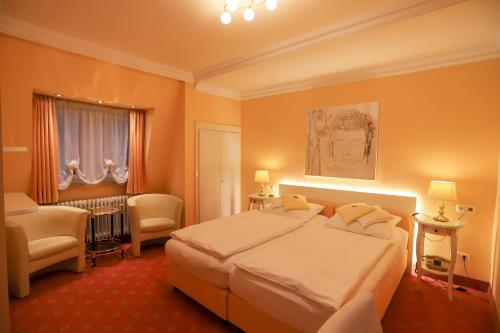 ein Hotelzimmer mit einem großen Bett und einem Wohnzimmer in der Unterkunft Hotel Modena in Bad Steben