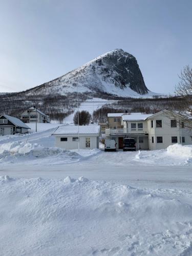 een met sneeuw overdekte parkeerplaats met een berg op de achtergrond bij Fjordgård B in Tofta