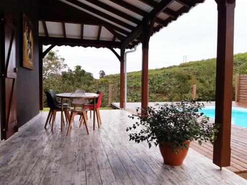 a patio with a table and chairs on a deck at Villa Tourmaline in Le Lorrain