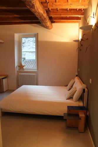 a bedroom with a white bed with a window at New Fontana Rooms in Como