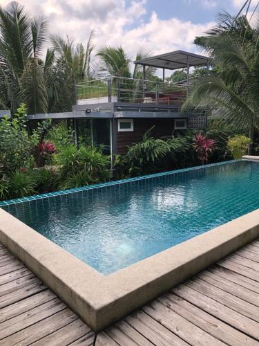 a swimming pool in front of a house at Baan Boom Boxes Eco Friendly Resort in Mae Nam