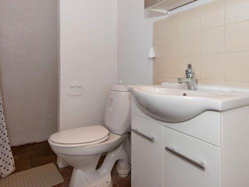 biała łazienka z toaletą i umywalką w obiekcie Holiday Home Lyngvejen IV w mieście Rømø Kirkeby