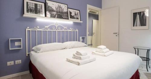een slaapkamer met een groot wit bed en handdoeken bij Modern apartment in Milan in Milaan