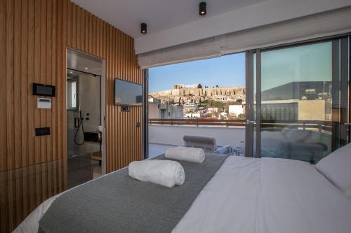 a bedroom with a bed with a view of a city at Acropolis Golden Suites by GHH in Athens