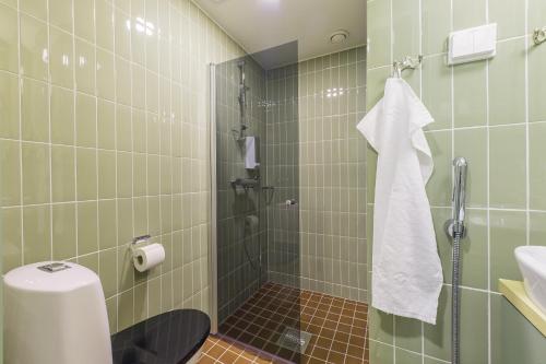 y baño con ducha, aseo y lavamanos. en Forenom Aparthotel Jyväskylä, en Jyväskylä