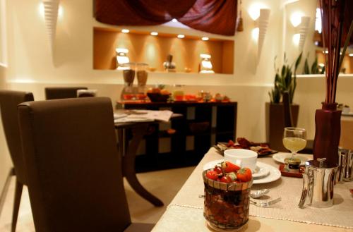a table topped with a bowl of fruit and a glass of wine at Hotel Latinum in Rome