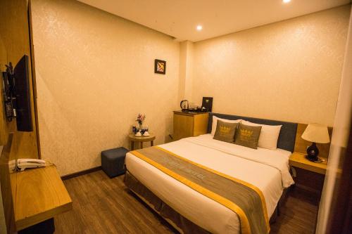 a bedroom with a large bed in a room at The Blue Airport Hotel in Ho Chi Minh City