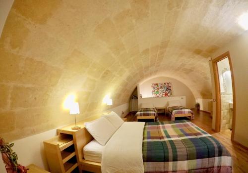 una camera con letto king-size su un muro di pietra di Casa SantoStefano a Matera