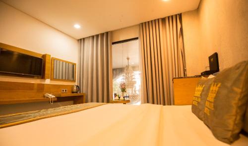 a hotel room with a bed and a television at The Blue Airport Hotel in Ho Chi Minh City