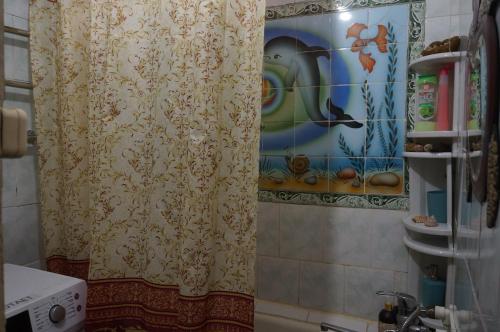 cortina de ducha en un baño con una pintura en la pared en Always at home - Apartments at Klimasenko 11 block 7, en Novokuznetsk