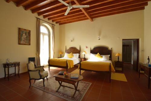 1 dormitorio con 2 camas, sofá y mesa en Quinta Do Scoto, en Sintra