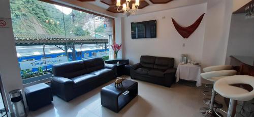 a living room with a couch and chairs and a table at Flower's House MachuPicchu in Machu Picchu