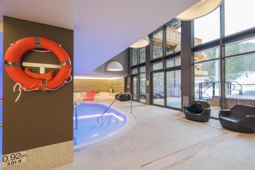 a large room with a swimming pool and an orange life preserver at Residence l Hevana - maeva Home in Méribel