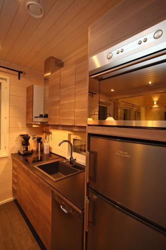 a kitchen with a stainless steel refrigerator and a sink at Himos Villa Nummenranta 2 in Säyrylä