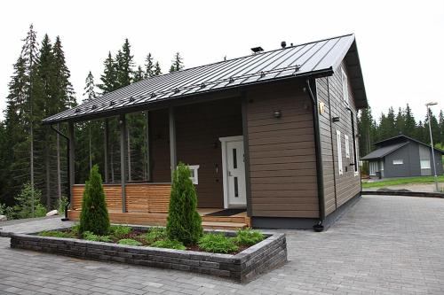 a small house with a roof on a patio at Himos Villa Nummenranta 2 in Säyrylä