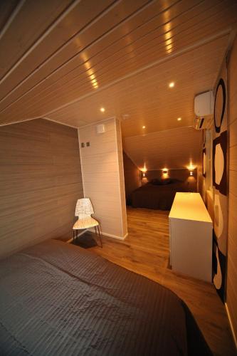 a small room with a bed and a small chair at Himos Villa Nummenranta 2 in Säyrylä