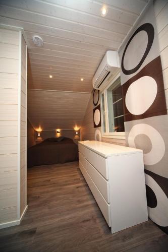 a bathroom with a vanity and a bed in a room at Himos Villa Nummenranta 2 in Säyrylä