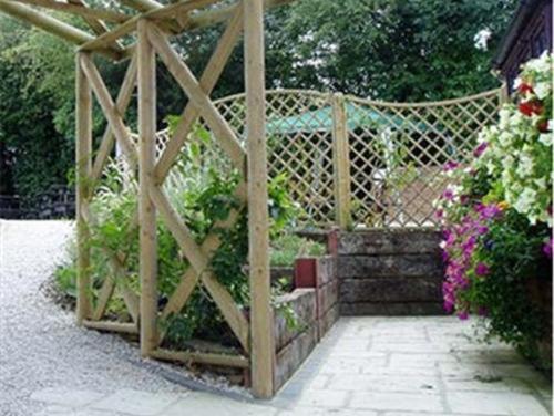 un giardino con recinzione in legno e fiori di The Wheatsheaf Inn a Cuckfield