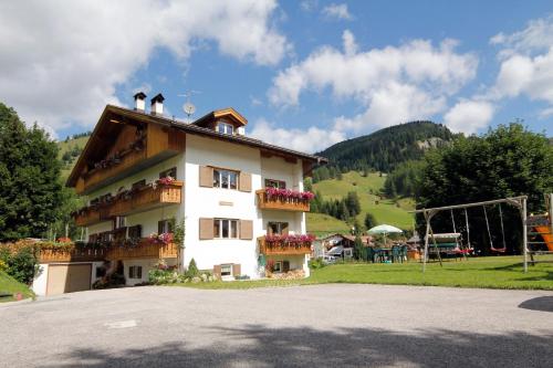 a building with flowers on the balconies and a playground at Appartamenti Lezuo Iris in Arabba