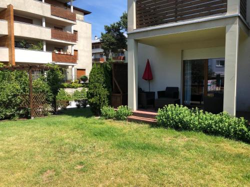 a house with a lawn in front of a building at Apartamenty Bałtyckie - Wczasowa - osiedle zamknięte, winda, miejsce parkingowe in Ustka