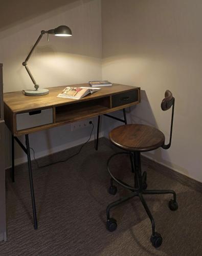 a wooden desk with a lamp and a chair at ZENTRUM Hotel in Chişinău