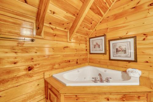 ein Badezimmer mit einer Badewanne in einer Holzhütte in der Unterkunft Treehouse in Pigeon Forge