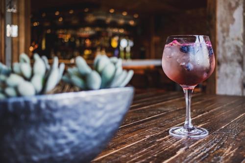 un verre de vin assis sur une table avec un cactus dans l'établissement Becketts, à Portsmouth