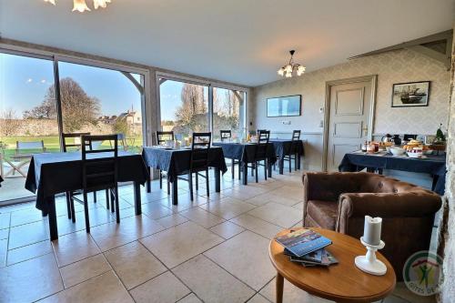 une salle à manger avec des tables et des chaises ainsi qu'une grande fenêtre dans l'établissement Gentilhommière de la Grande Toutenais, à Saint-Malo