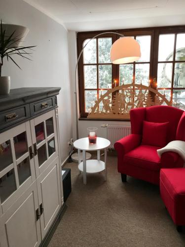 a living room with a red couch and a table at Auersberg Haus in Eibenstock