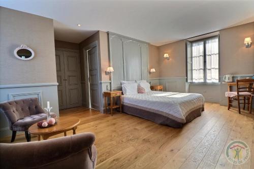 a bedroom with a bed and a chair and a table at Gentilhommière de la Grande Toutenais in Saint Malo