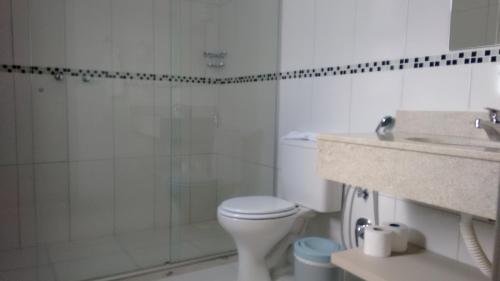 a white toilet sitting next to a sink in a bathroom at Coral Hotel proximo a Pucrs e Araujo Viana in Porto Alegre