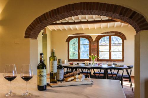 two bottles of wine sitting on a table with wine glasses at Castello La Leccia in Castellina in Chianti