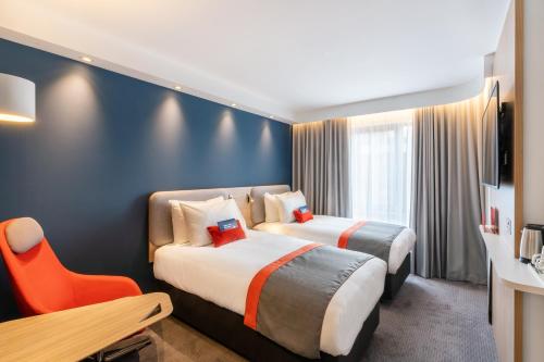 a hotel room with two beds and a table and a desk at Holiday Inn Express - Derry - Londonderry by IHG in Derry Londonderry