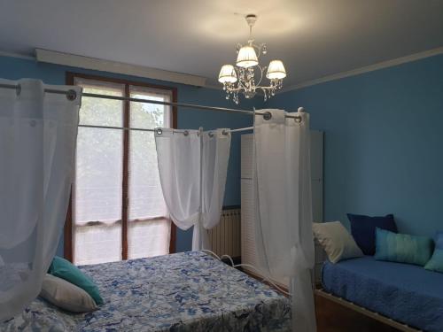 a bedroom with a bed and a window and a chandelier at Villa Ferrari Oriella in Solignano Nuovo