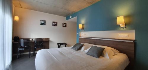 a bedroom with a large white bed with two pillows at The Originals Boutique, Hôtel La Chaussairie, Rennes Sud in Chartres-de-Bretagne