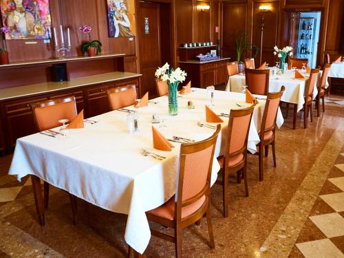 a dining room with tables and chairs with white table cloth at Hradná stráž Hotel&Apartments s privátnym wellness in Topoľčianky