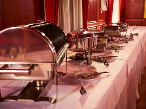 a long table with dishes and pots and pans on it at Hradná stráž Hotel&Apartments s privátnym wellness in Topoľčianky