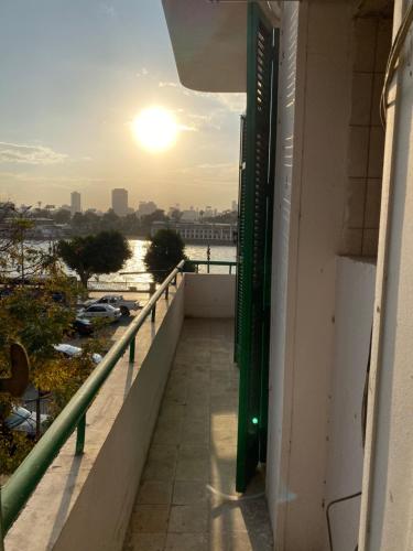 a view from the balcony of a building with the sunset at Brassbell l Downtown l Maspero in Cairo