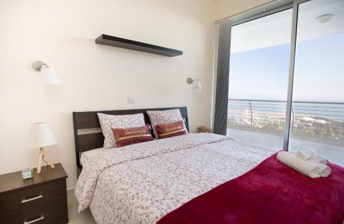 een slaapkamer met een bed en een groot raam bij Promenade Seaview Heaven in Larnaka