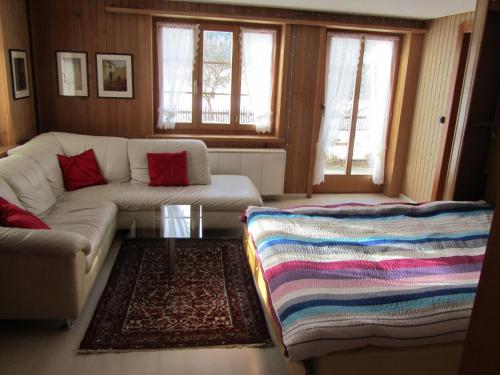 ein Wohnzimmer mit einem Sofa und einem Tisch in der Unterkunft Chalet Halten in Lenk im Simmental