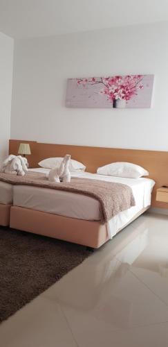 Apartamentos DECOR في تارافال: غرفة نوم مع سرير مع اثنين من الحيوانات المحشوة عليه