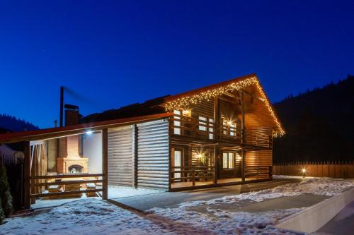 a wooden house with christmas lights on it at night at Bambetli in Tatariv
