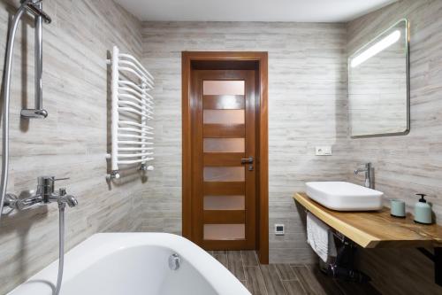 a bathroom with a white tub and a sink at Bambetli in Tatariv