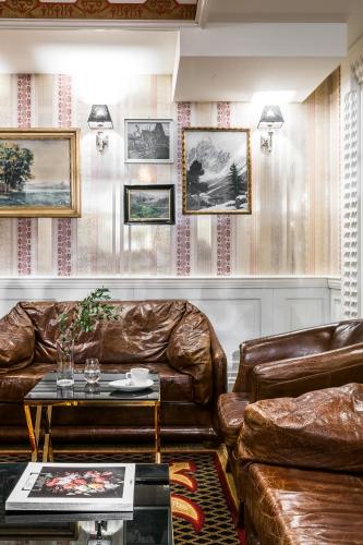 a living room with two leather couches and a table at Aries Hotel & SPA Wisła in Wisła
