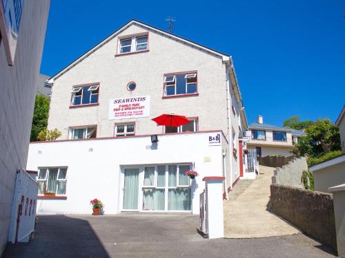 a white building with a red umbrella on it at Seawinds Bed and Breakfast in Killybegs