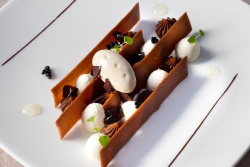 a white plate with chocolate waffles and balls of ice cream at Château & Spa De La Commanderie in Eybens