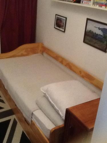 a small bed in a room with a table at Logement avec magnifique vue des montagnes in Digne-les-Bains