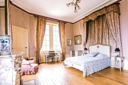 1 dormitorio con 1 cama y 1 silla en Château Belle Epoque - Chambres d'Hôtes & Gîtes, en Linxe