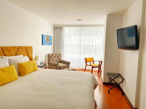 a hotel room with a bed and a flat screen tv at Pop Art Hotel Manizales Centro Histórico in Manizales