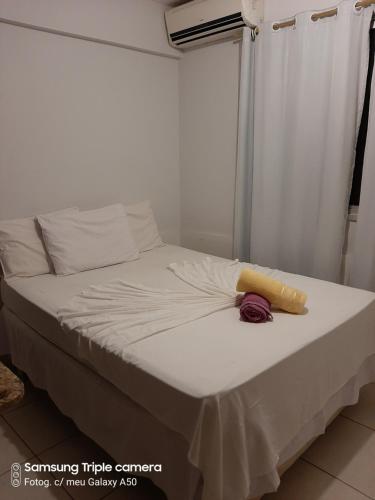 Cama en habitación con sábanas y almohadas blancas en #Flats Studio 45 Bueno Oeste, en Goiânia
